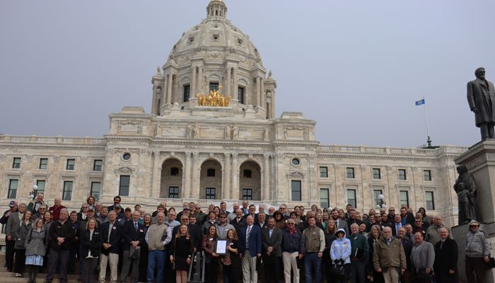 group of 130 people standing on steps in front of the Minnesota State Capitol