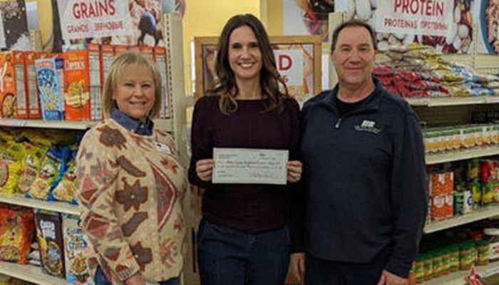 three individuals standing together during check presentation