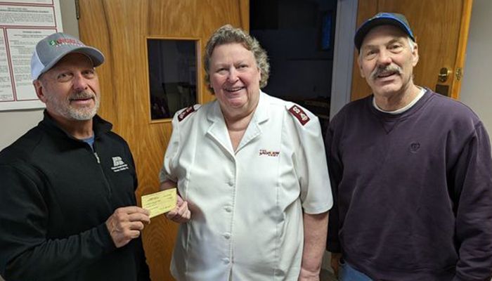 three individuals standing together during check presentation
