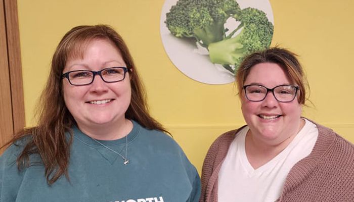 two individuals, one presenting check