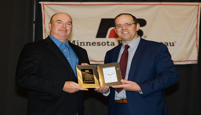 two men on stage holding an award