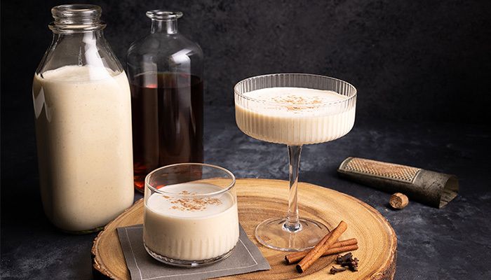 photo of eggnog in glass with ingredients surrounding it