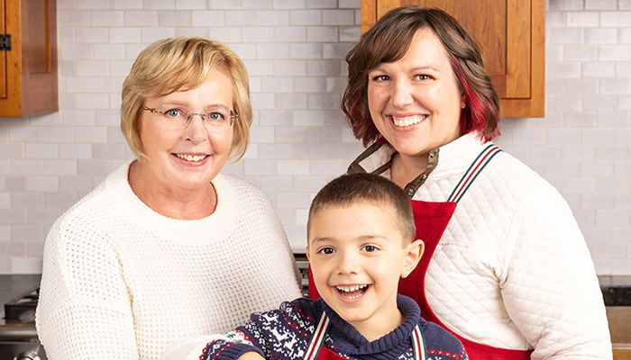Three family  members baking together by mixing dough