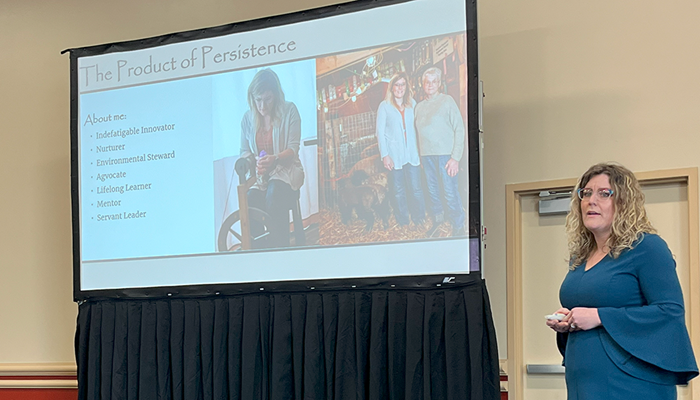 woman standing in front of screen giving presentation