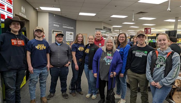 group of students and adults posed for group photo in a grocery store