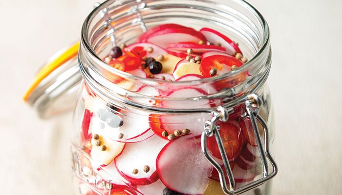 overhead photo of pickled radishes in a glass jar