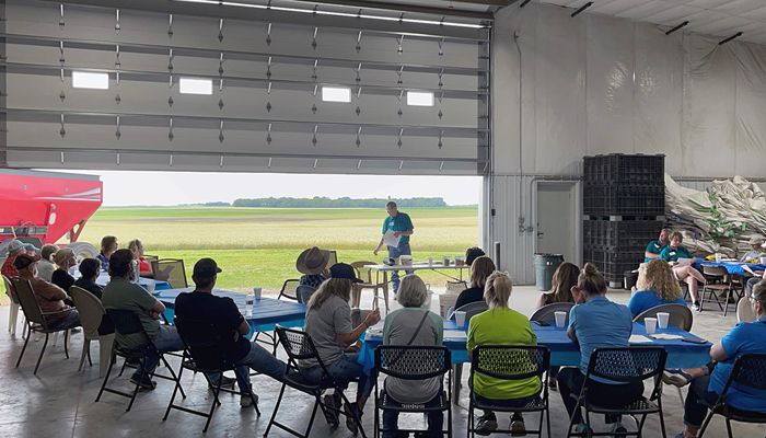 large group of people sitting at tables listening to a speaker