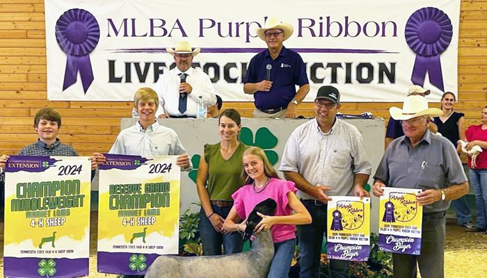 group of people holding banners and standing with a sheep