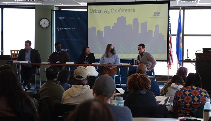 group of people listening to panel speakers on stage