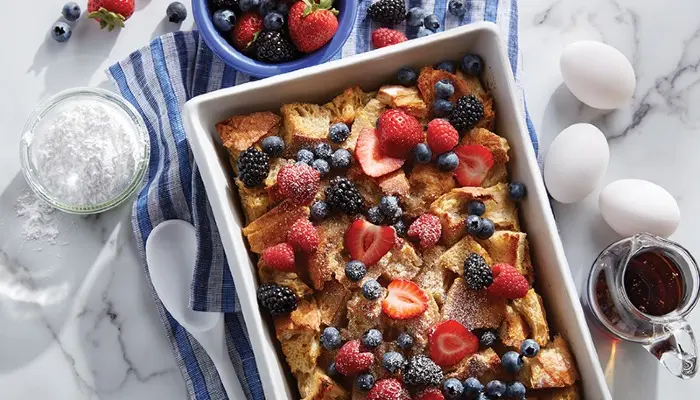 overhead shot of overnight french toast with ingredients scattered around finished product