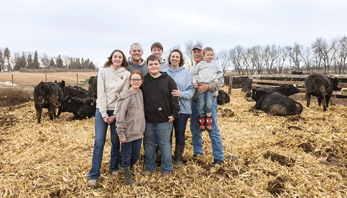 family members standing with cattle on farm