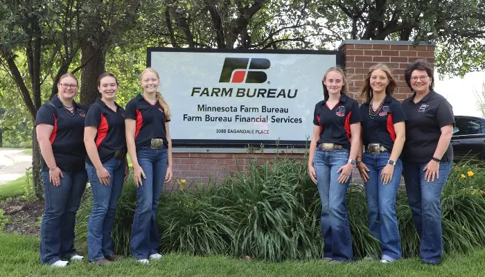 Beef Ambassadors stand in front of Farm Bureau sign