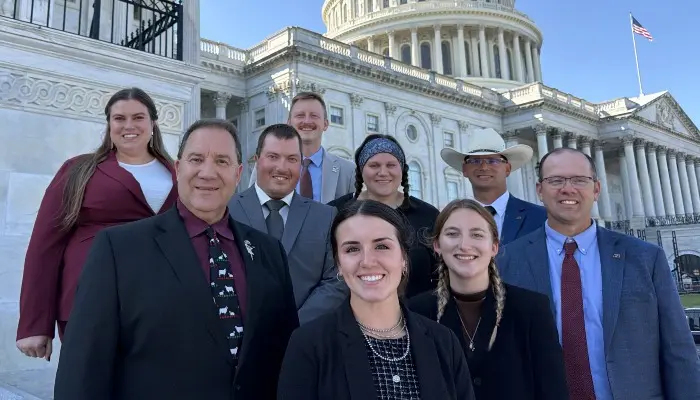 group of people standing on steps in front of Capitol in DC