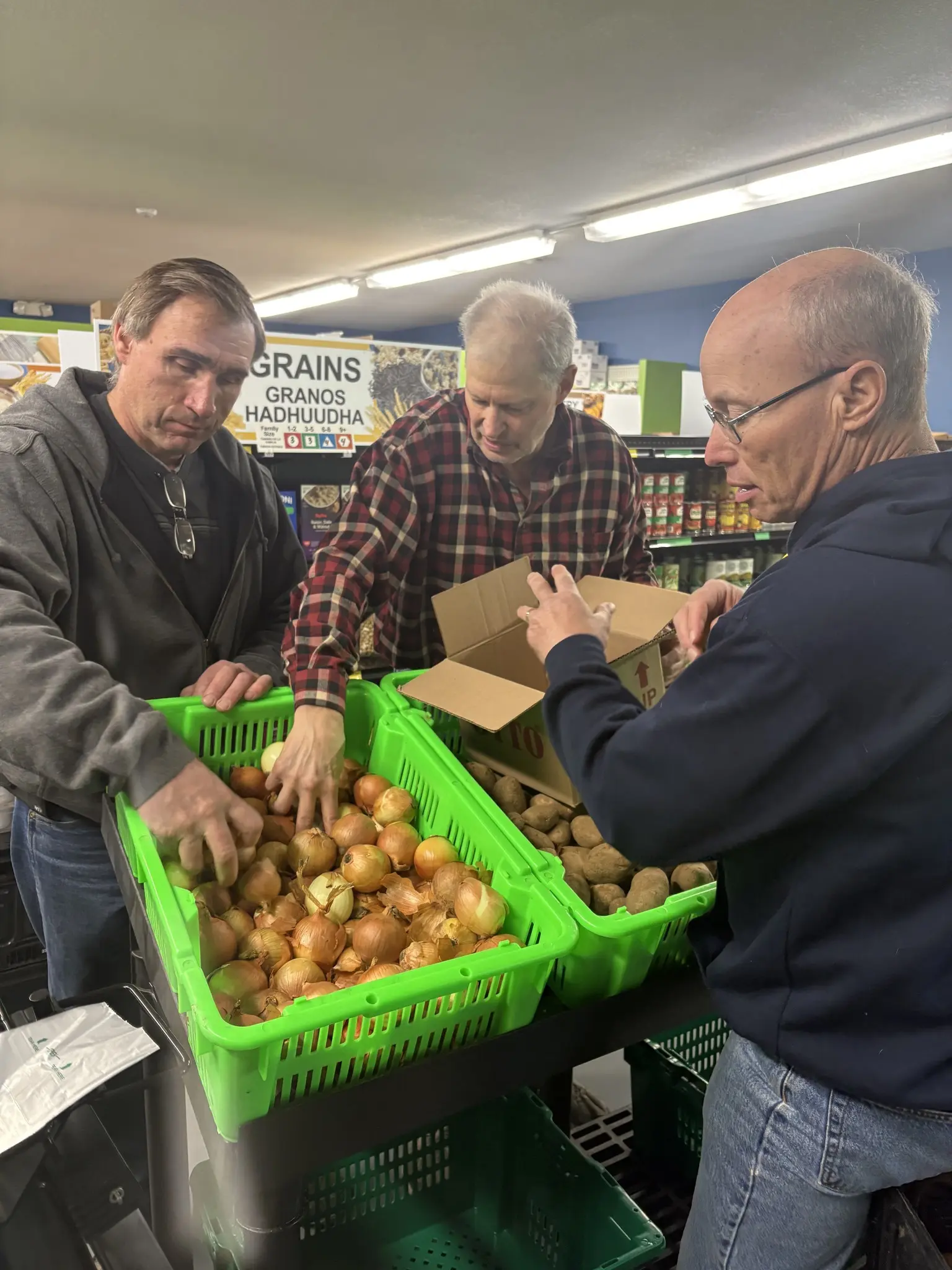 group of three people packaging onions at a food shelf